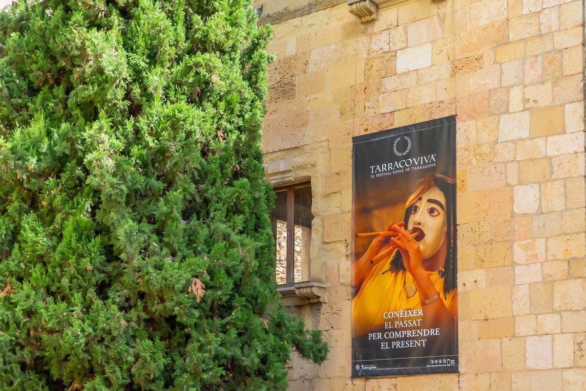 Affiche du festival Tarraco Viva sur un mur de pierre de la vieille ville.