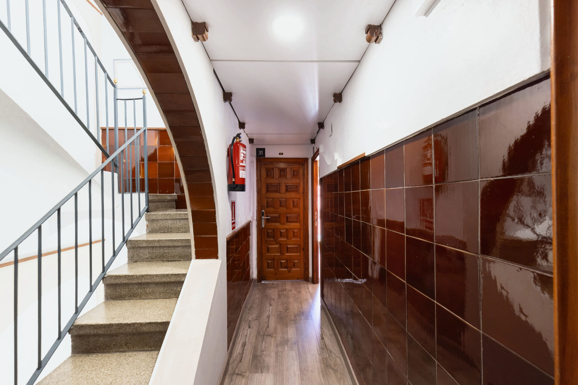 Escalier en terrazzo avec garde-corps noir.