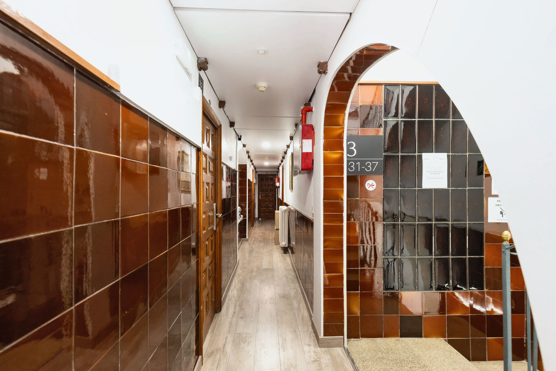 Couloir avec carrelage d'origine et portes en bois.